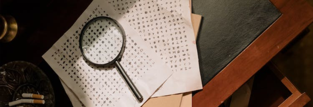 Magnifying glass above a table full of papers featuring runes.