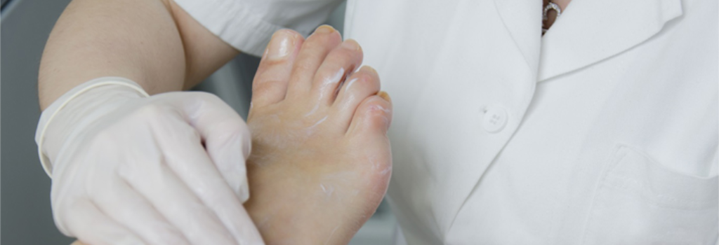 A healthcare professional applies moisturising cream to a patient's foot